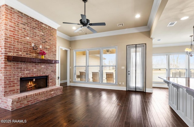 unfurnished living room featuring crown molding, dark hardwood / wood-style floors, ceiling fan with notable chandelier, and a fireplace