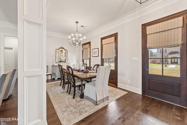 dining room with dark hardwood / wood-style flooring, ornamental molding, and a chandelier