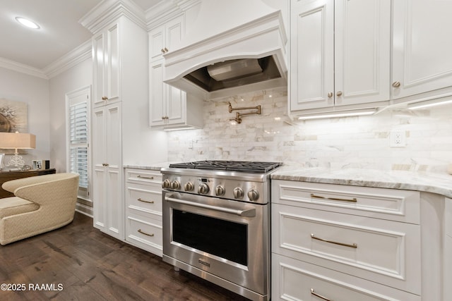 kitchen featuring white cabinetry, high end range, ornamental molding, custom range hood, and backsplash