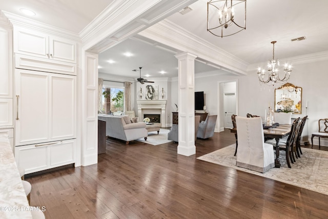 dining area with ceiling fan with notable chandelier, ornamental molding, dark hardwood / wood-style floors, and ornate columns