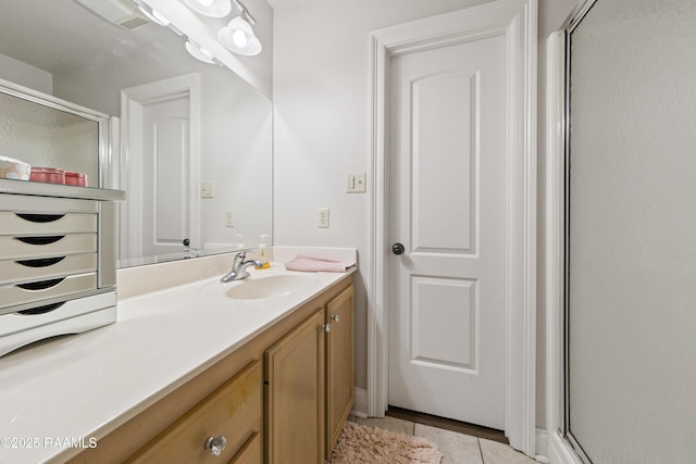 bathroom featuring vanity, tile patterned floors, and a shower with shower door