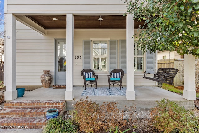 view of exterior entry featuring covered porch