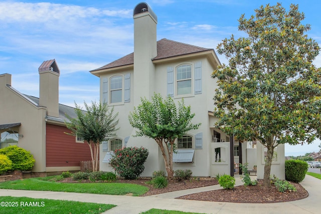 211 Bayonne Dr, Lafayette, LA 70507 - view of front facade with a chimney, a shingled roof, and stucco siding