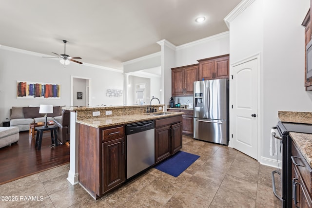 kitchen with sink, dark brown cabinets, ornamental molding, an island with sink, and stainless steel appliances