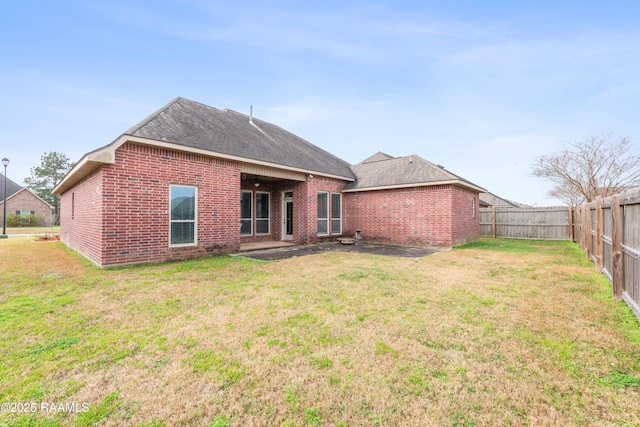 back of property featuring a lawn and a patio