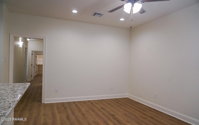 empty room with dark wood-type flooring and ceiling fan