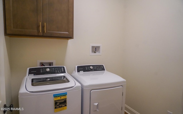 laundry area with washer and clothes dryer and cabinets