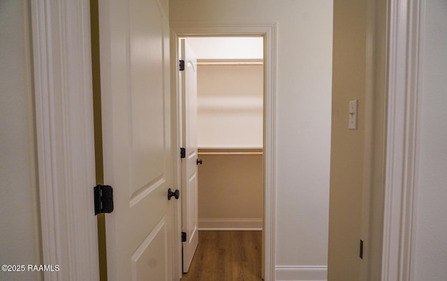 corridor with hardwood / wood-style flooring