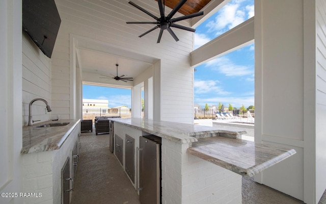 view of patio / terrace with wine cooler, sink, ceiling fan, and an outdoor kitchen