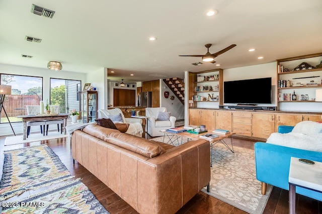 living area featuring visible vents, dark wood finished floors, ceiling fan, stairs, and recessed lighting