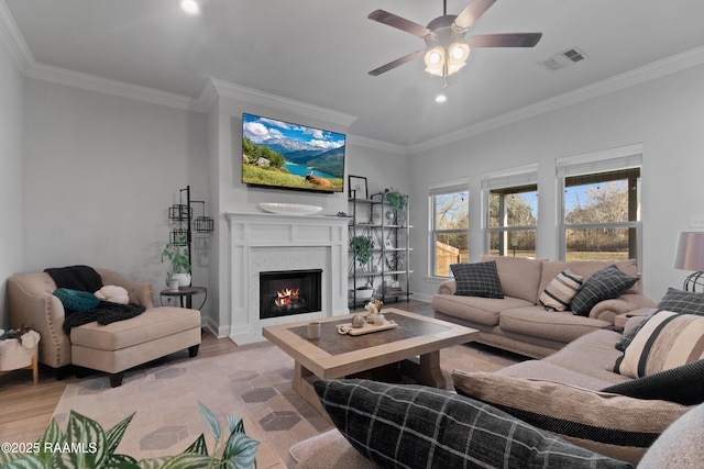 living room featuring crown molding, ceiling fan, and light wood-type flooring