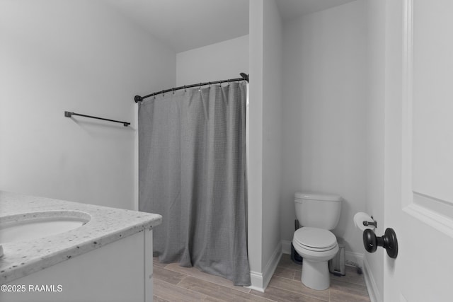 bathroom featuring vanity, curtained shower, and toilet