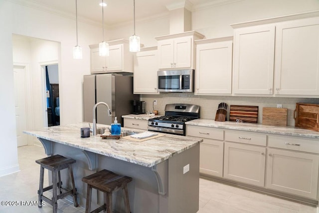 kitchen featuring a kitchen breakfast bar, pendant lighting, stainless steel appliances, light stone countertops, and a kitchen island with sink
