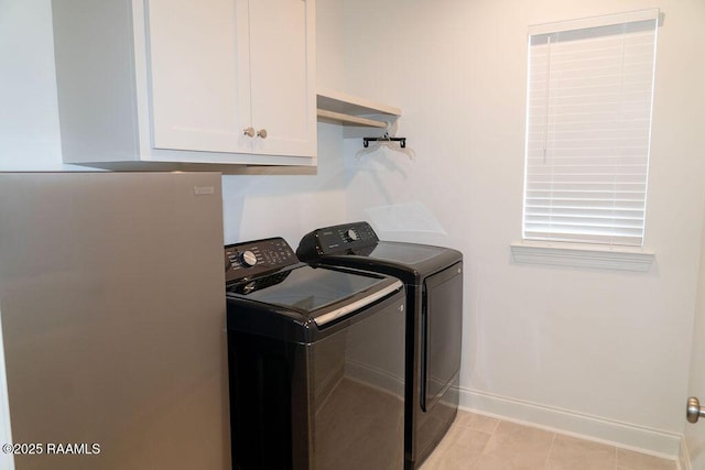 washroom featuring cabinets, washer and dryer, and light tile patterned floors