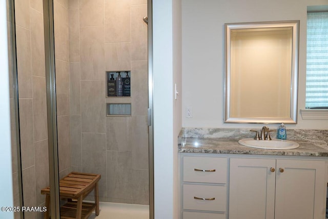 bathroom with a shower with door and vanity