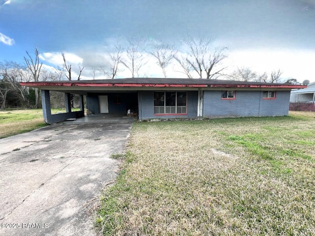 single story home featuring brick siding, concrete driveway, a front lawn, and an attached carport