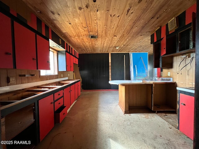 kitchen with wooden ceiling, red cabinets, and finished concrete floors