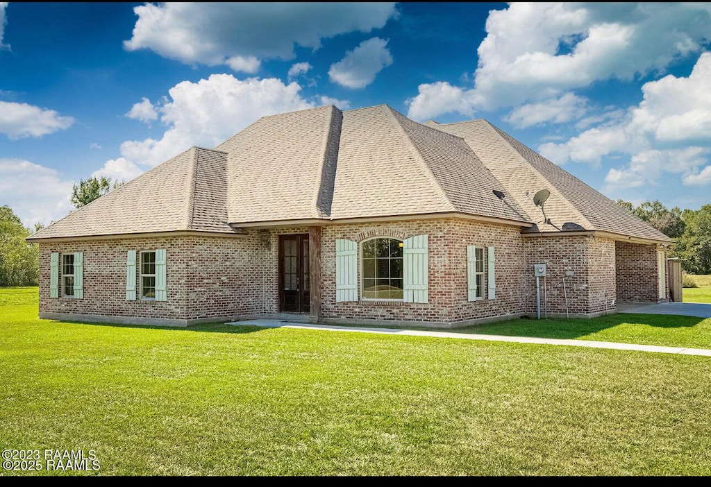 rear view of property featuring a yard