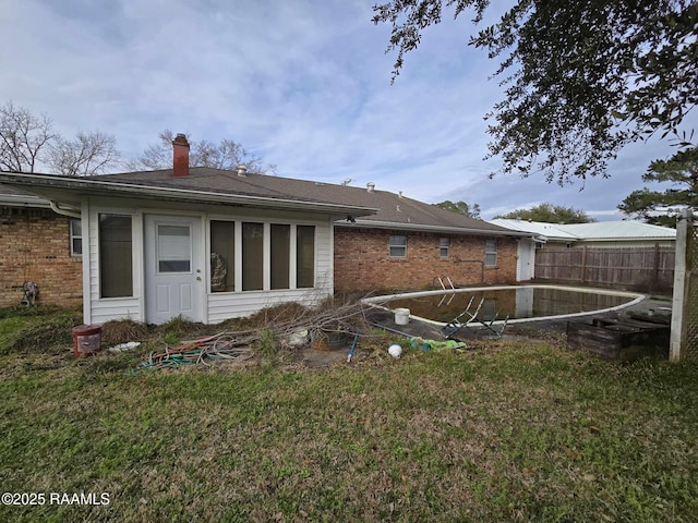 rear view of property featuring a yard