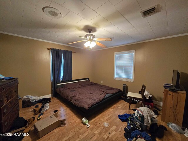 bedroom featuring crown molding, hardwood / wood-style floors, and ceiling fan