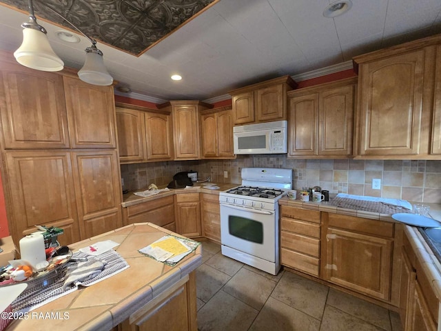 kitchen featuring tile countertops, white appliances, and decorative backsplash