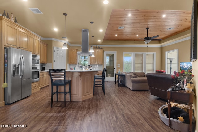 kitchen with a kitchen island, appliances with stainless steel finishes, island range hood, a kitchen bar, and light brown cabinets