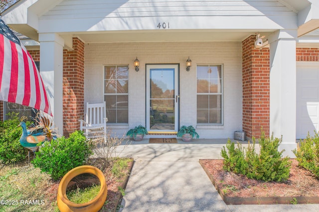 property entrance with brick siding and covered porch