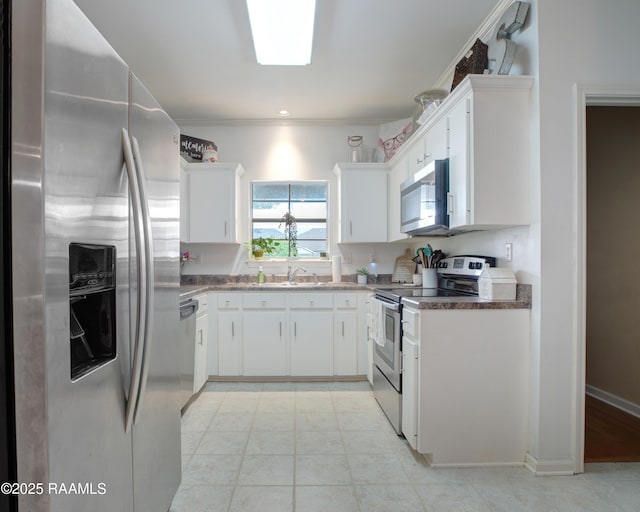 kitchen featuring a sink, ornamental molding, stainless steel appliances, and white cabinetry