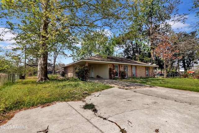 view of front of house featuring driveway, an attached carport, stucco siding, fence, and a front lawn