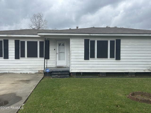 view of front of property featuring a front lawn and roof with shingles