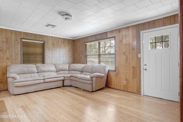 living room with ornamental molding and light wood-type flooring