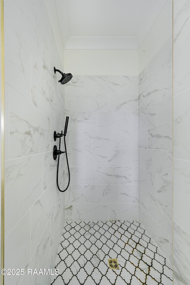 bathroom with crown molding and tiled shower