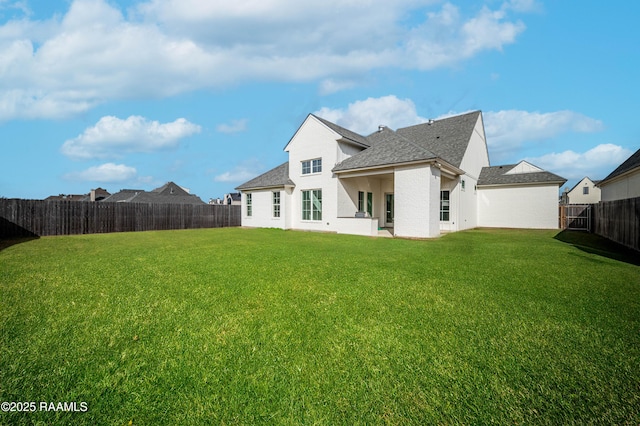 rear view of house featuring a yard