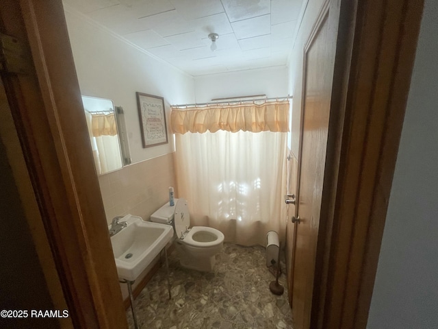 full bathroom with toilet, sink, crown molding, shower / tub combo, and tile walls