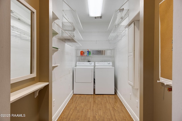 washroom featuring visible vents, baseboards, laundry area, washer and dryer, and light wood-type flooring