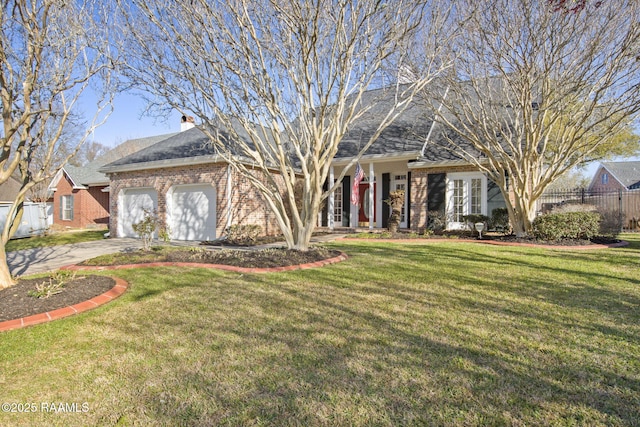 view of front of property with brick siding, an attached garage, a front lawn, fence, and driveway