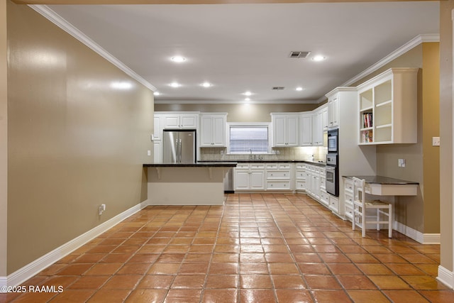 kitchen with ornamental molding, appliances with stainless steel finishes, white cabinetry, dark countertops, and tasteful backsplash