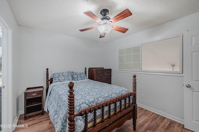 bedroom with ceiling fan, hardwood / wood-style floors, and a textured ceiling