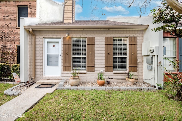 doorway to property featuring a lawn