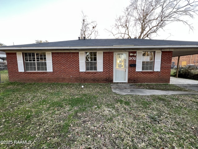 ranch-style house with brick siding, a front lawn, and an attached carport