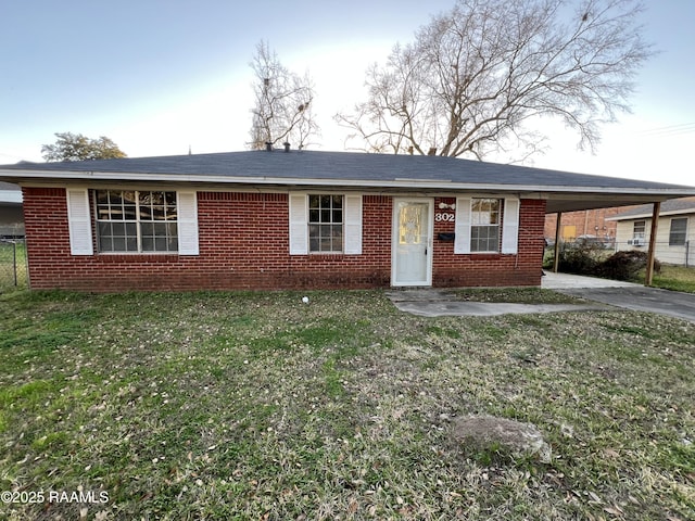 ranch-style house with driveway, brick siding, a front yard, and an attached carport