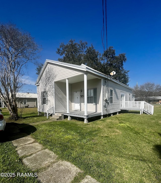 view of side of property with a yard and covered porch