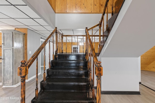 staircase with a paneled ceiling and hardwood / wood-style floors