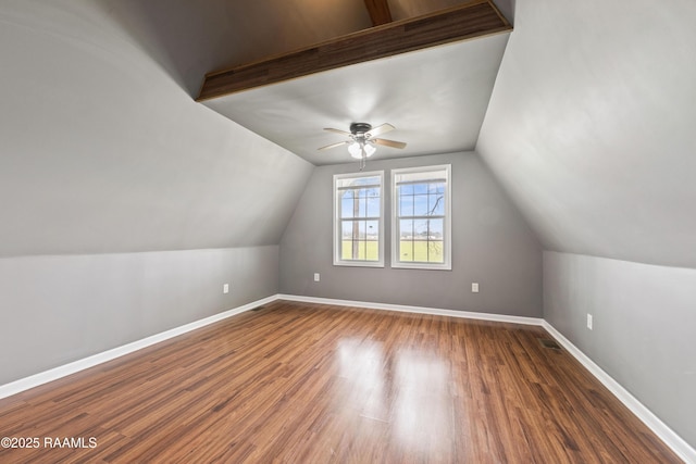 additional living space with lofted ceiling, dark hardwood / wood-style floors, and ceiling fan