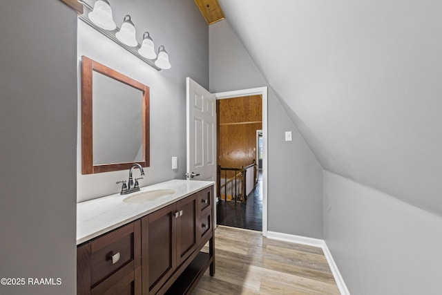 bathroom featuring vanity, lofted ceiling, and hardwood / wood-style floors