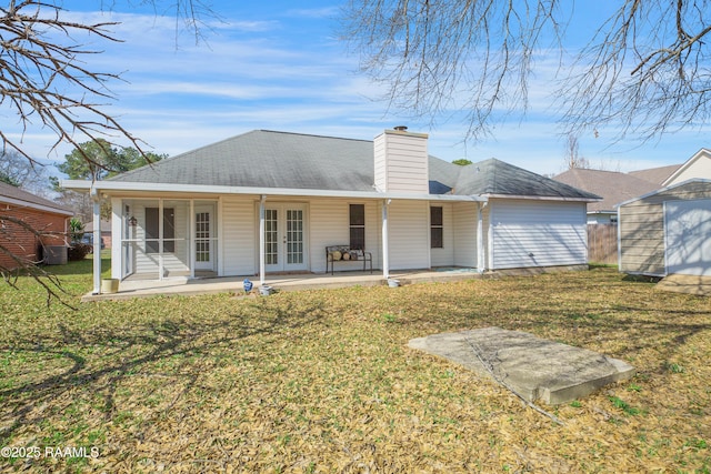 back of property featuring a yard, a patio area, and a shed