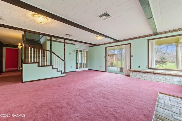 unfurnished living room featuring beamed ceiling, a healthy amount of sunlight, and carpet flooring