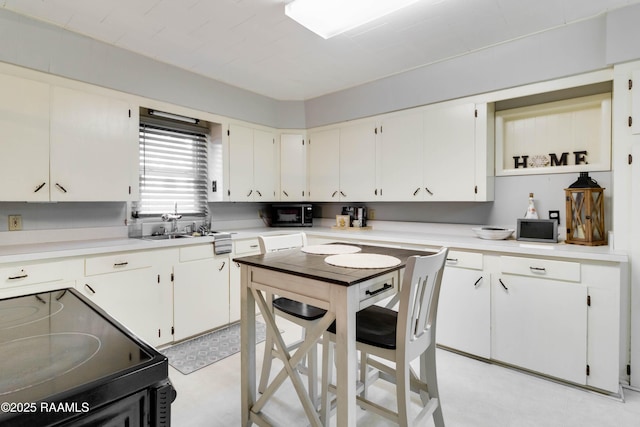 kitchen with light countertops, electric range, light floors, and white cabinets