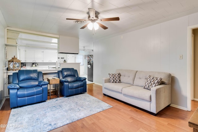 living area with ceiling fan, light wood-type flooring, visible vents, and baseboards