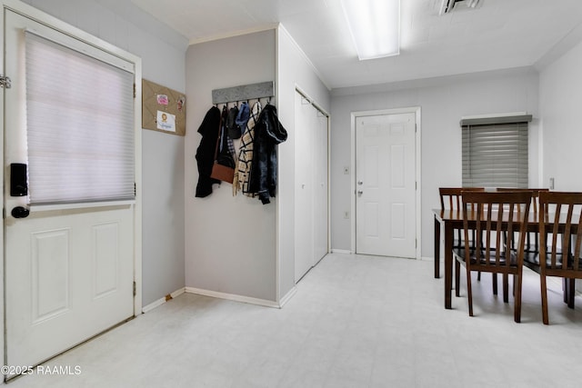 foyer with baseboards, light floors, visible vents, and crown molding